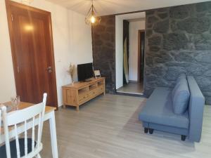 a living room with a blue couch and a tv at Drop Point in Santo Amaro