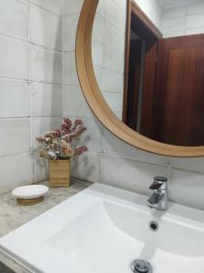 a bathroom with a white sink and a mirror at Drop Point in Santo Amaro