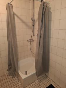 a shower in a tiled bathroom with a tub at Apartment B&J Cochem in Cochem