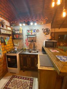 a kitchen with a stove and a sink in it at Cabana 3 Fazenda in São Francisco de Paula