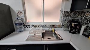 a kitchen counter with a sink and a window at Departamento 5 Min Centro Wifi Elevador in Pátzcuaro +7 photos