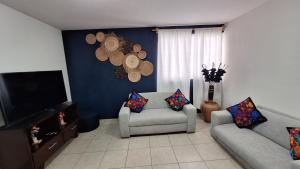 a living room with two couches and a flat screen tv at Vistas de Pátzcuaro 104 in Pátzcuaro