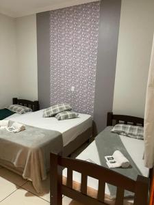 ein Schlafzimmer mit 2 Betten und einer Wand mit einem Muster in der Unterkunft Angelo Reservas in Olímpia