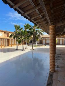 an empty courtyard with palm trees in a building at Pousada frente mar in Beberibe