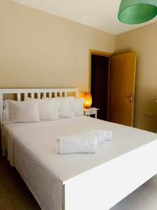 a bedroom with a large white bed with towels on it at VillaDelphia in Kefallonia