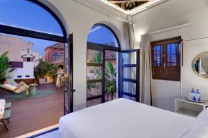 a bedroom with a bed and an open door to a balcony at Coeo Fresca Roof Garden Signature Apartments in Málaga