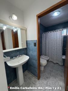 a bathroom with a sink and a toilet and a mirror at Departamentos Rufino in Rufino +19 photos