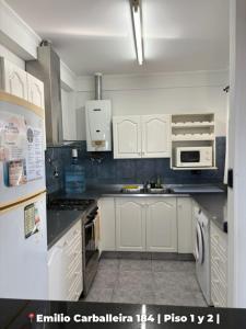 a kitchen with white cabinets and white appliances at Departamentos Rufino in Rufino