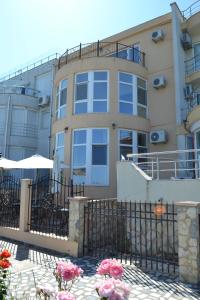 un bâtiment avec une clôture et des fleurs devant dans l'établissement Le Soleil de Paris, à Eforie Nord 3 autres photos