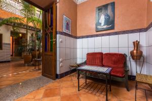 ein Wohnzimmer mit einem roten Sofa und einem Tisch in der Unterkunft Hotel Atlas in Marrakesch