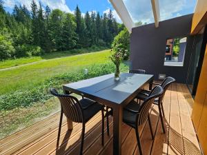 a table and chairs on a deck with a view at Chalets Hrabovo in Ružomberok