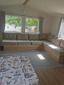 a living room with a couch and a bed at Thorness bay caravan park in Isle of Wight +14 photos