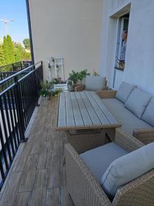 patio ze stołem i kanapami na balkonie w obiekcie Husarska Swinemünde w Świnoujściu