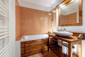 a bathroom with a sink and a bath tub at Appartement Abries - Jacuzzi et piscine - Pied des pistes - Duplex 6 personnes - Résidence étoilée in Abriès