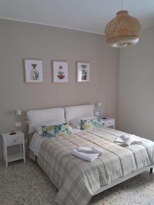 a white bedroom with a bed with towels on it at Anna Luxury Apartment in Bisceglie