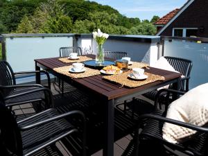 a wooden table with plates of food on a patio at Flussblick am Töpferberg 8 in Bad Schwartau