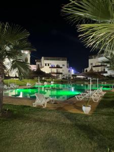 a swimming pool at night with green lights at Cabo House in Cabo Negro