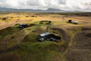 Panorama Glass Lodge SOUTH في هيلاّ: اطلالة جوية على مزرعة فيها شاحنة على تلة