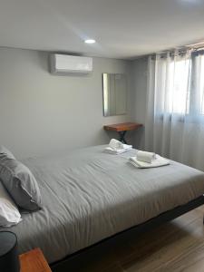 a bedroom with a bed with two towels on it at Recanto da Boucinha - T2 in Veade +7 photos