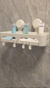 Dos inodoros en un estante con tazas encima. en Tafamba Apartments, en Harare