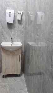 un baño con lavabo y ducha en Tafamba Apartments, en Harare