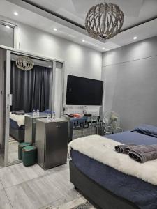 Un dormitorio con dos camas y un televisor de pantalla plana. en Tafamba Apartments, en Harare