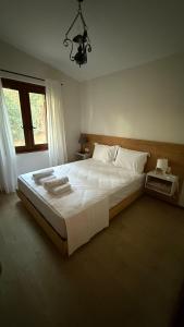 une chambre avec un grand lit blanc et une fenêtre dans l'établissement villa King Filippos by the sea, à Nikiti