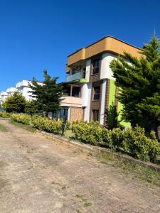 a building with trees on the side of a dirt road at Seyran Seaside Apartments- 2-garden floor in Trabzon +6 photos