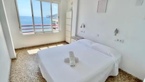 ein weißes Zimmer mit einem Bett, auf dem ein Teddybär liegt in der Unterkunft Liberty 4 personas Calpe centro in Calpe