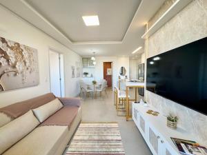 Μια τηλεόραση ή/και κέντρο ψυχαγωγίας στο Apto em Home Club com vista para piscina - 550m do mar