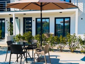 a patio with a table and chairs and an umbrella at TaNa's Apartments in Donji Štoj