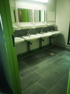 a public bathroom with three sinks and mirrors at grand tipi traditionnel pour 2 à 5 personnes in Montbrun
