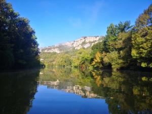 a river with trees and a mountain in the background at grand tipi traditionnel pour 2 à 5 personnes in Montbrun