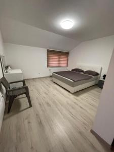 a bedroom with a bed and a chair in it at Aia Holiday Home in Sarajevo
