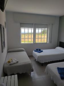 a white room with two beds and a window at Dukes Habitaciones in Bascuas +79 photos