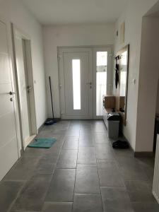 a hallway with a door and a tile floor at Aia Holiday Home in Sarajevo