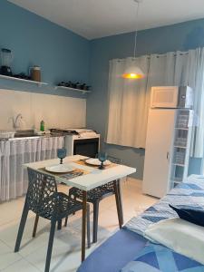 a kitchen with a table and chairs in a room at Chale Vista ao Mar Blue in Caucaia +6 photos