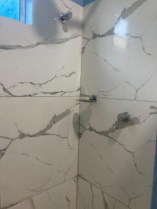 a bathroom with a shower with marble tiles at Chale Vista ao Mar Blue in Caucaia