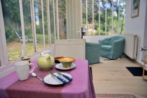 a table with a purple table cloth with plates and cups at BB Villa Sainte Marie in Limoux