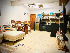 a living room with a couch and a table and a kitchen at Flic en Flac Beachfront Apartment, KAZAFIBI in Flic-en-Flac
