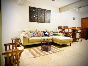 a living room with a couch and a table at Flic en Flac Beachfront Apartment, KAZAFIBI in Flic-en-Flac +62 photos