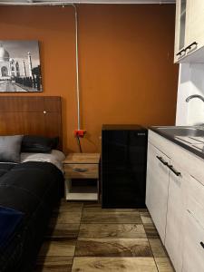 una pequeña cocina con sofá y fregadero en Alojamiento Mosaic House, en Bogotá