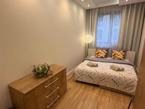 a bedroom with a bed and a dresser and a window at Lubicz Apartment 70m2 in Kraków