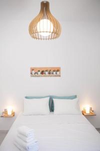 una camera da letto con un letto bianco e un lampadario di Luxury Apartment in the Center ad Atene
