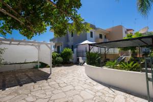 a patio with a white pergola next to a building at villetta rosa blu marina di modica in Marina di Modica