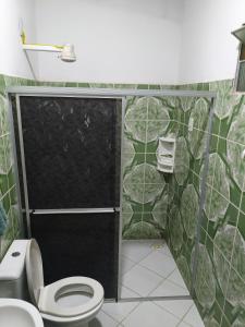 a bathroom with a toilet and a black shower stall at Condomínio em Canoa Quebrada in Aracati