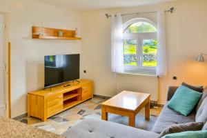 een woonkamer met een bank, een tv en een tafel bij House MaLa in Senj