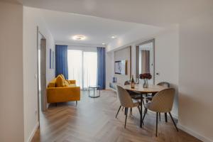 a living room with a dining room table and a yellow couch at R&M Residence in Pécs
