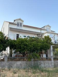 a white house with trees in front of it at Melija Apartment in Orebić