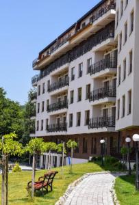 a large white building with benches in a park at Una LUX N85 in Kopaonik